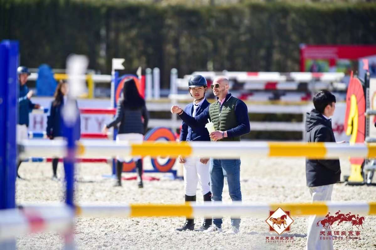 Coaching auf dem Turnierplatz: Trainer im Gespräch mit einer Reiterin